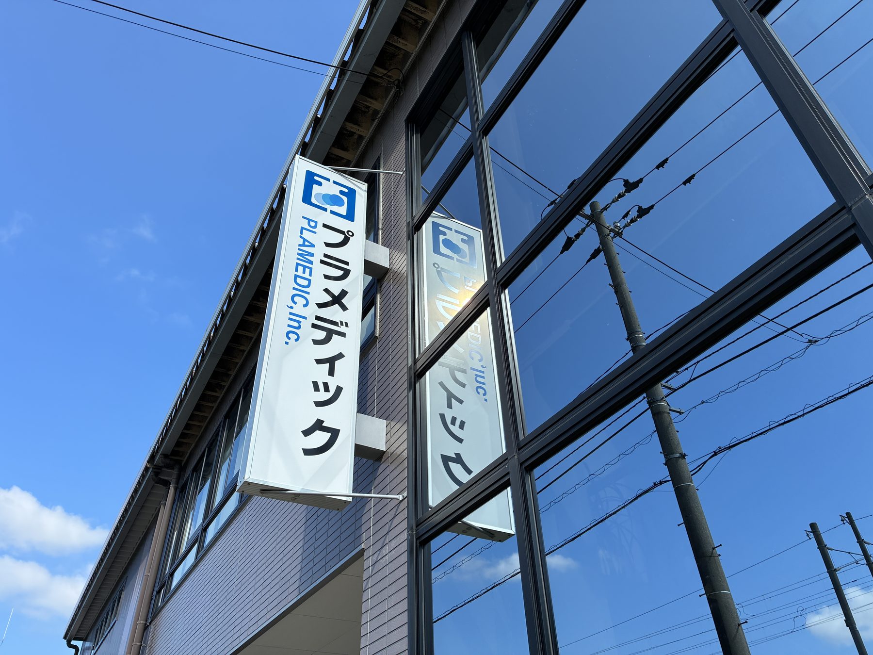 本社玄関脇に取り付けられた縦型の社名看板